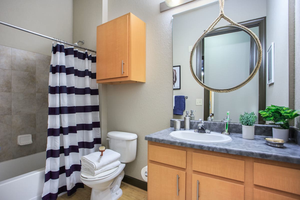 Model bathroom with a shower and large vanity at 4050 Lofts in Tampa, Florida