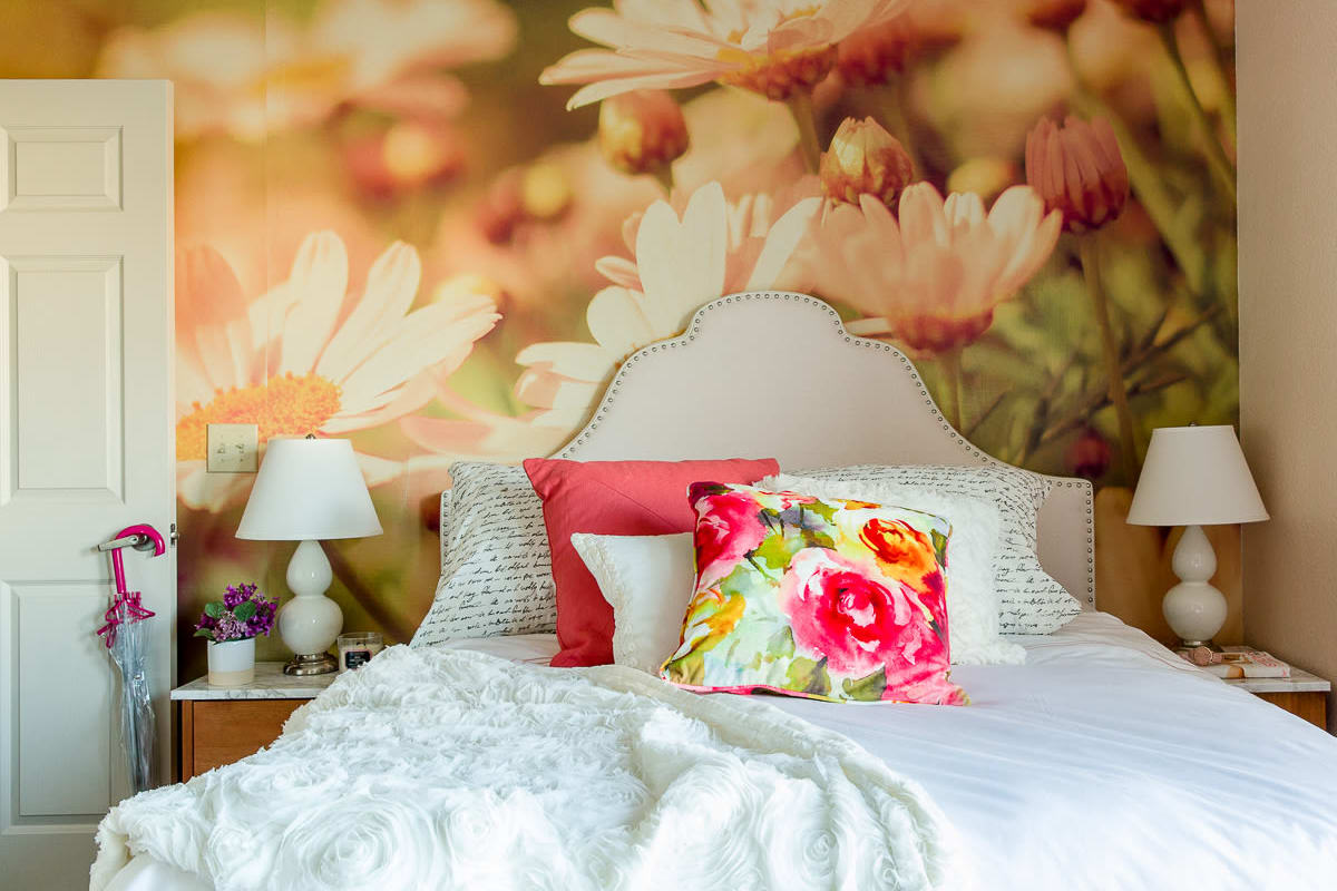 Model bedroom with a floral accent wall at The Holly in Lubbock, Texas
