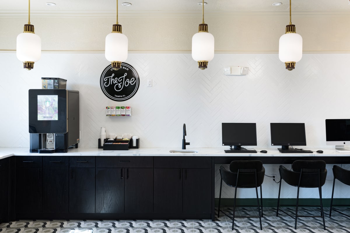The Joe coffee station and tech bar with Macs and PCs at 4050 Lofts in Tampa, Florida