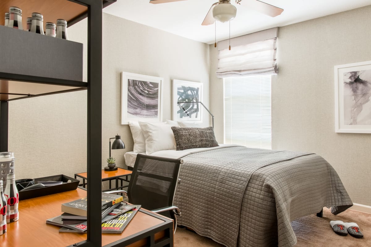 Model bedroom with a desk and lots of natural light at The Scarlet in Lubbock, Texas