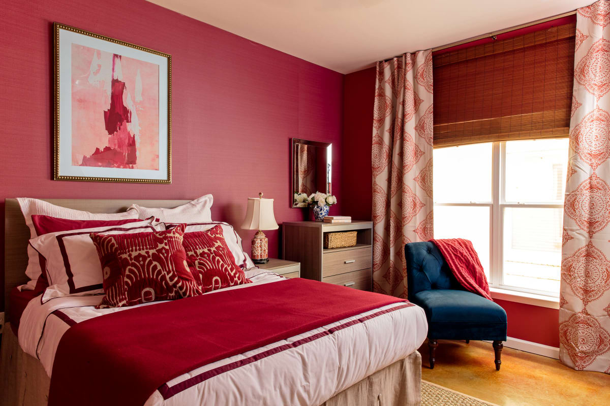 Spacious bedroom with a red accent wall at The Vic in Greensboro, North Carolina