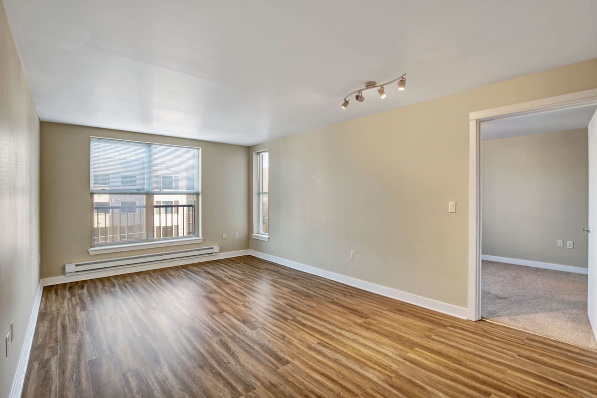 Large bay windows and hardwood flooring in an apartment's living area at Vantage Park Apartments in Seattle, Washington