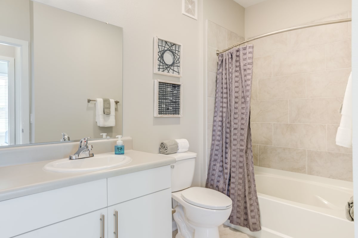 Bathroom with tiled flooring and a granite countertop in a model apartment home at The Pointe at Siena Ridge in Davenport, Florida