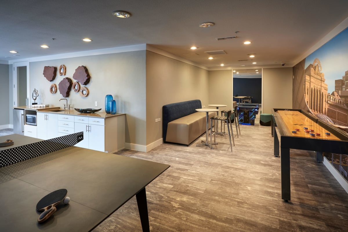 Awesome game room with shuffle board and a ping pong table for residents to play on at Marq Inverness in Englewood, Colorado