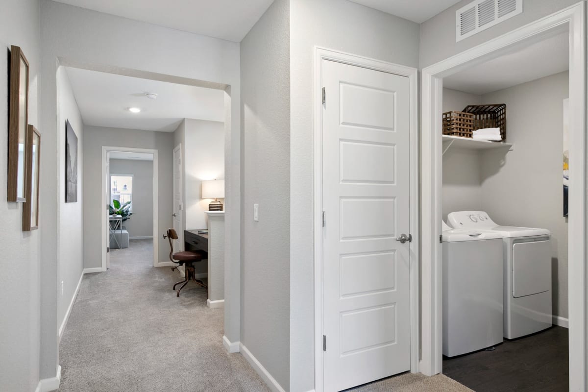 Spacious hallway with a washer and dryer at the end for easy laundry day at BB Living at Light Farms in Celina, Texas
