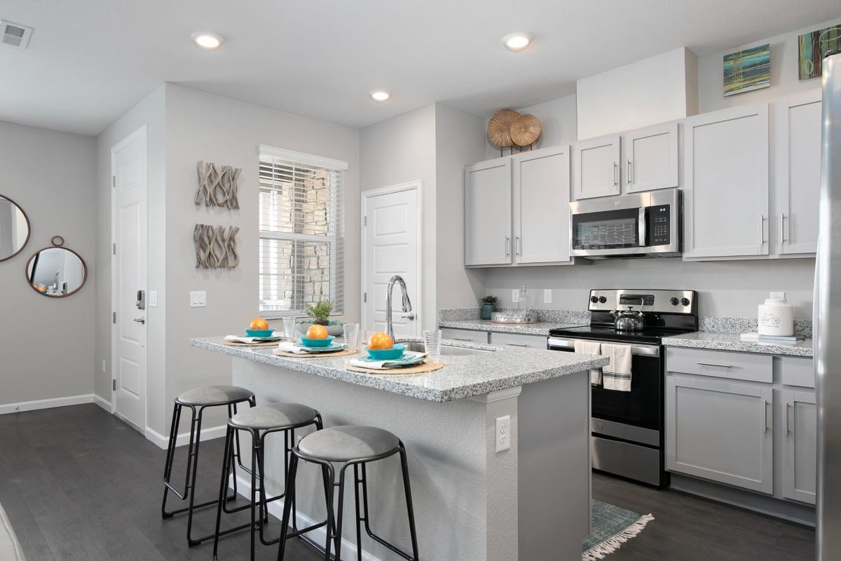 Sleek white cabinets and stainless steel appliances in the modern kitchen at BB Living Light Farms in Celina, Texas