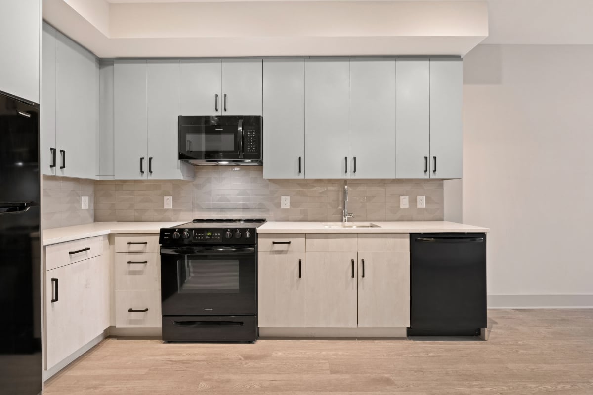 Very spacious and open kitchen with black appliances and two-tone cabinets at Big Sky Flats in Washington, District of Columbia