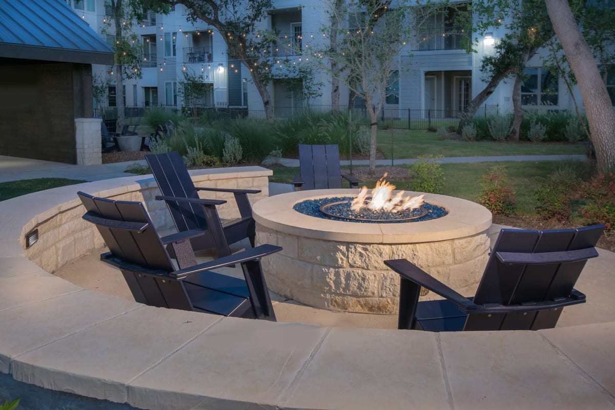 Modern firepit with a wall enclosing the space at Marquis Dominion in San Antonio, Texas