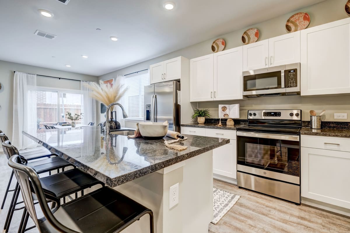 Sleek white cabinets and stainless steel appliances in the modern kitchen at BB Living Light Farms in Celina, Texas