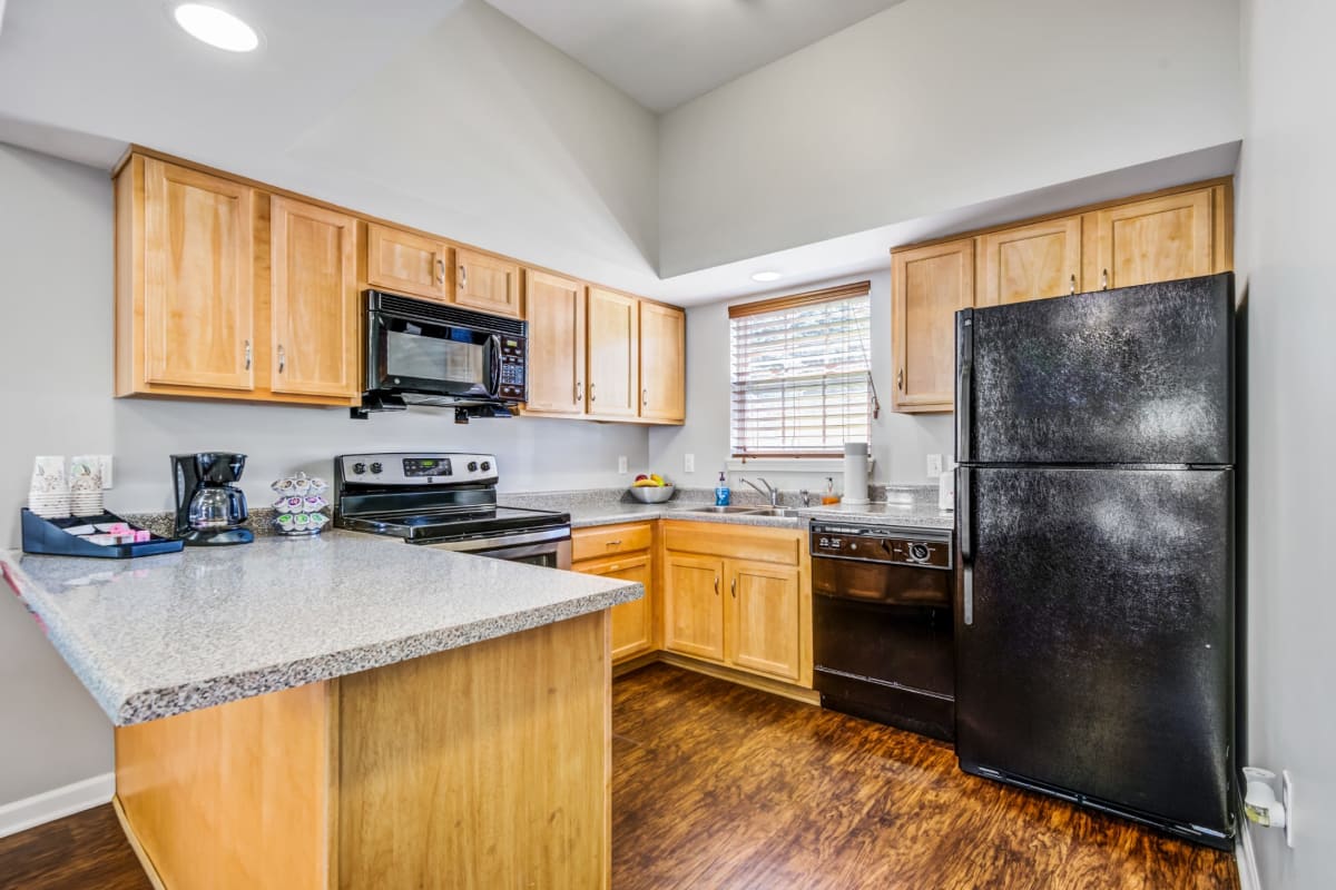 Kitchen with a breakfast bar and stainless steel appliances at Regency & Victor Villas Apartments in Victor, New York