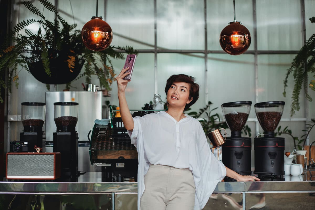 Woman taking a selfie at her favorite coffee shop at The Kendry in Charlotte, North Carolina