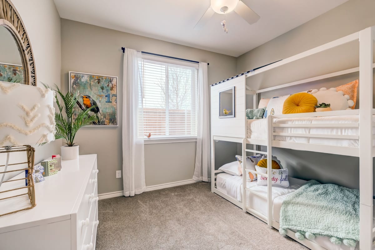 Bunk beds in a spacious bedroom with hardwood floors atBB Living Harvest in Argyle, Texas
