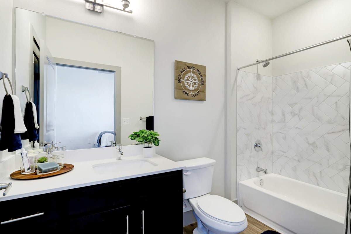 Model bathroom with a tub/shower combination at Tower 5040 in Houston, Texas
