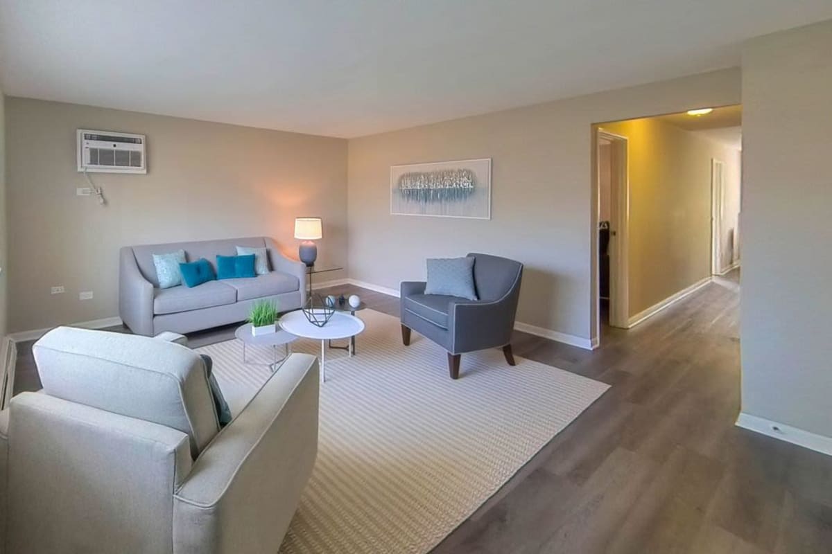 Model living space with light rug at Courtyards on the Park in Des Plaines, Illinois