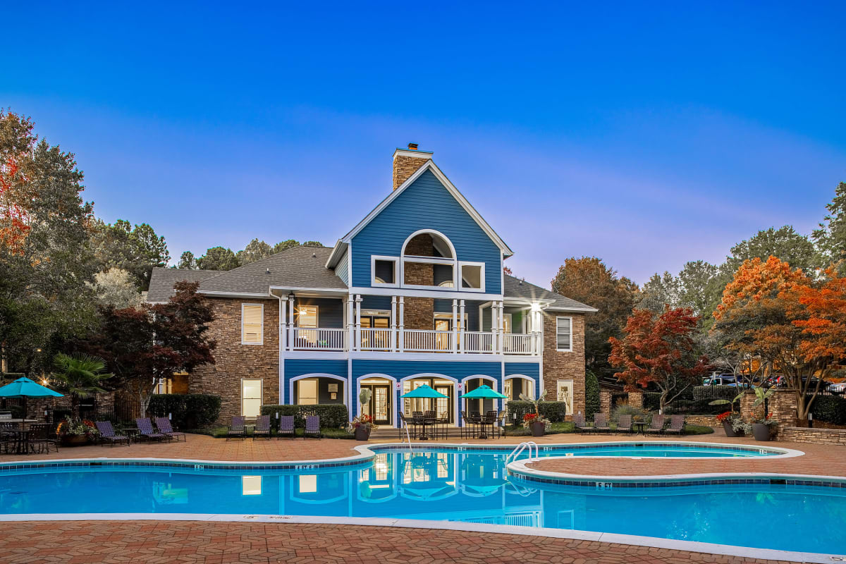 Evening view of clubhouse with pool at Marquis on Edwards Mill in Raleigh, North Carolina
