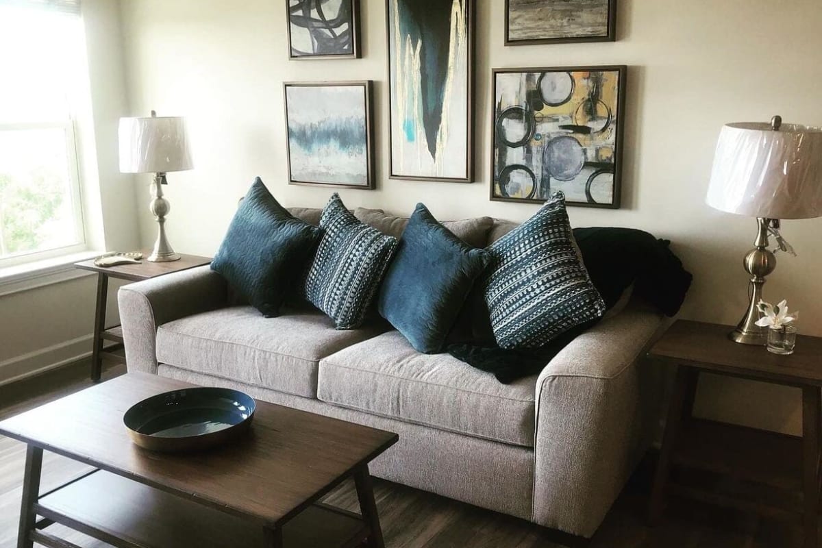 Furnished living room with sofa with decorative pillows and wooden coffee table at Trustwell Living of West Knoxville in Knoxville, Tennessee