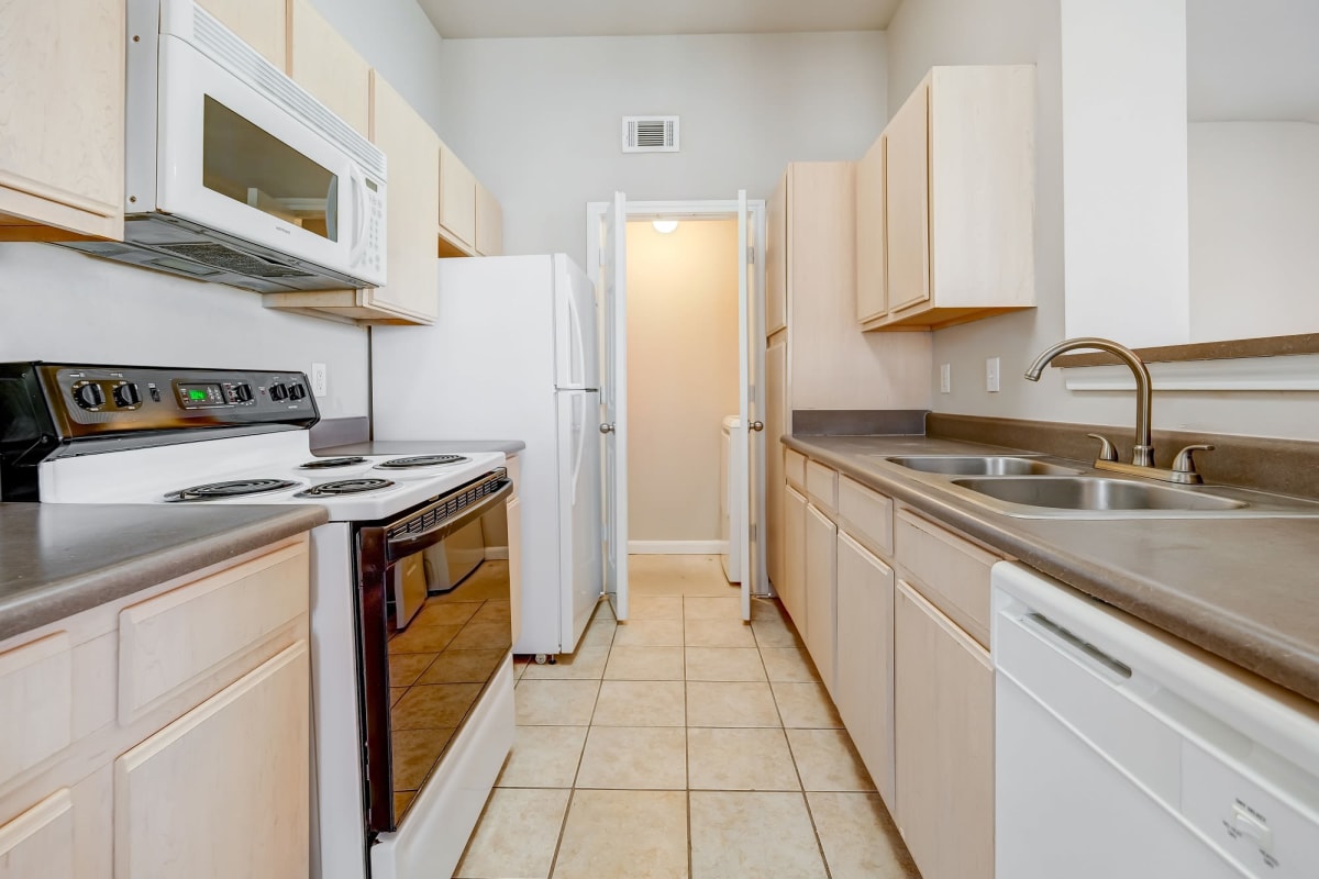 Bright kitchen with tile floors at Chateau des Lions Apartment Homes in Lafayette, Louisiana