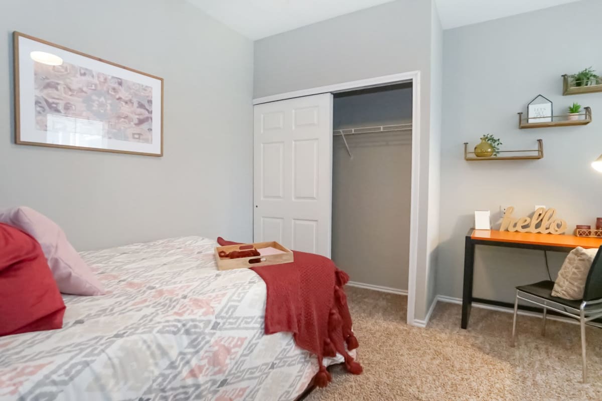 Decorated unit bedroom with small desk at The Leonard in Denton, Texas