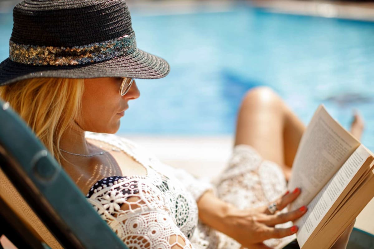 Resident reading a book by the pool at Boulder Creek in Riverside, California