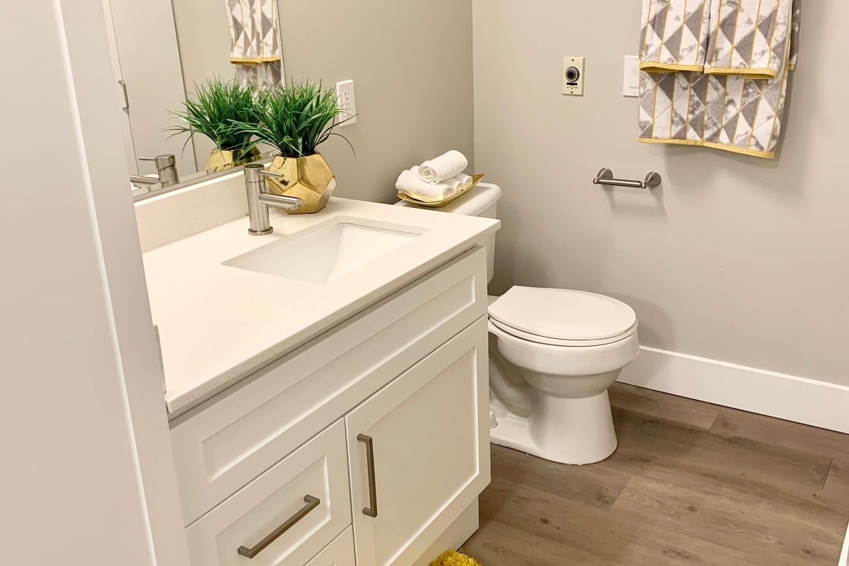 While toilet with sink and mirror at Vantage Park Apartments in Seattle, Washington