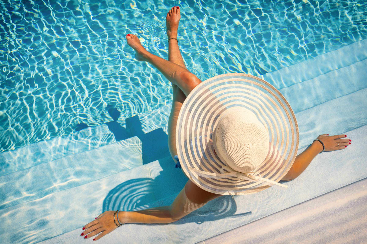 Resident with a hat relaxing on the poolside at The Bennett in Austin, Texas