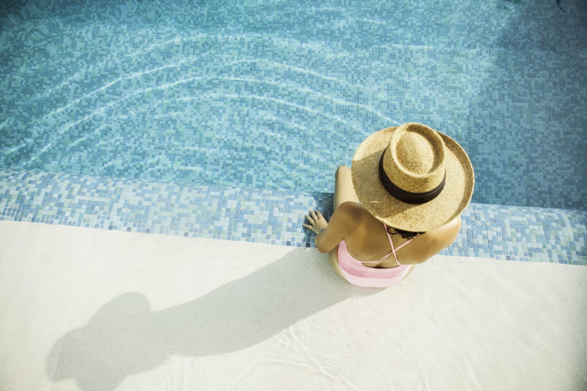 Woman putting her feet in the pool at Landmark Apartments Phase II in Little Rock, Arkansas