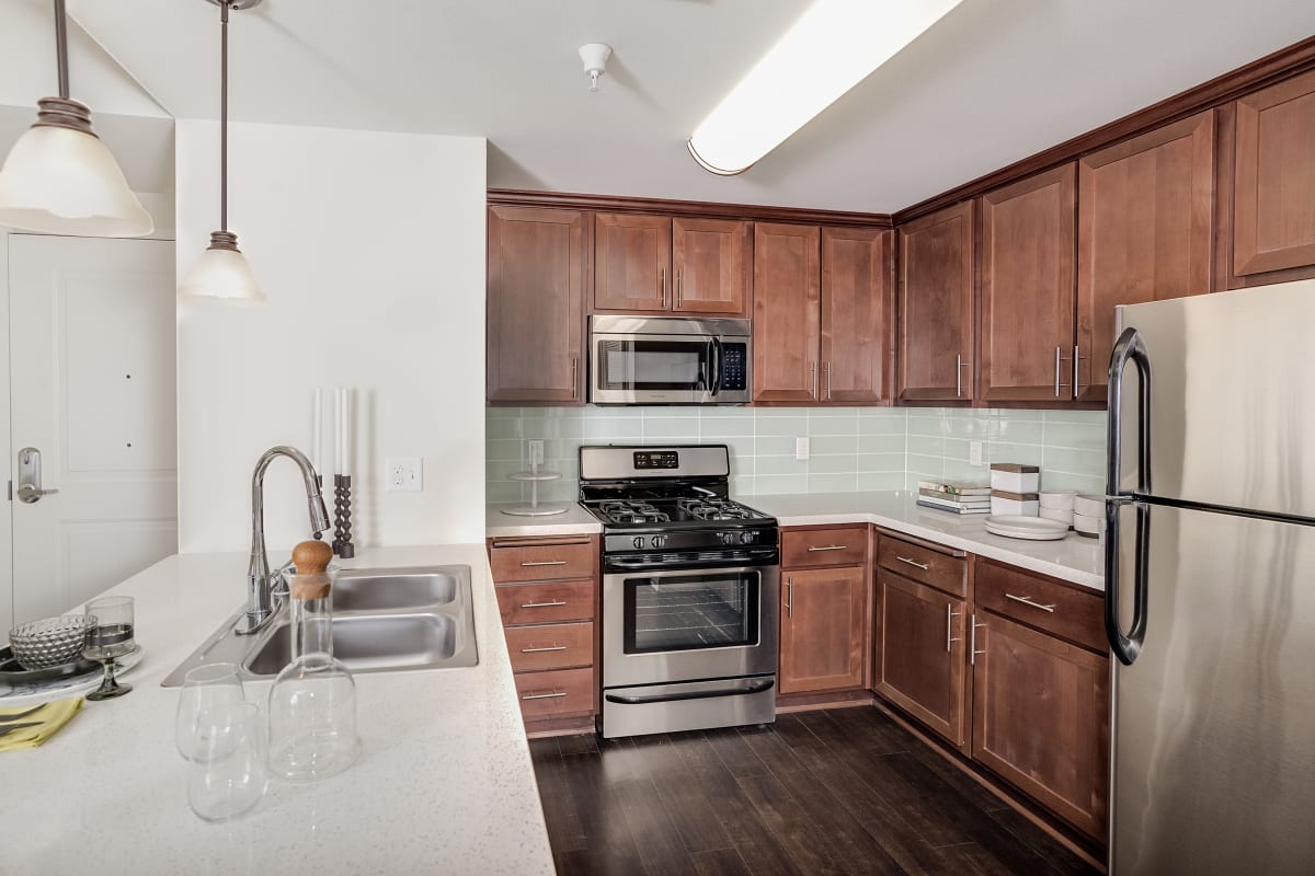 Kitchen with wood cabinets and stainless-steel appliances at Playa Del Oro, Los Angeles, California