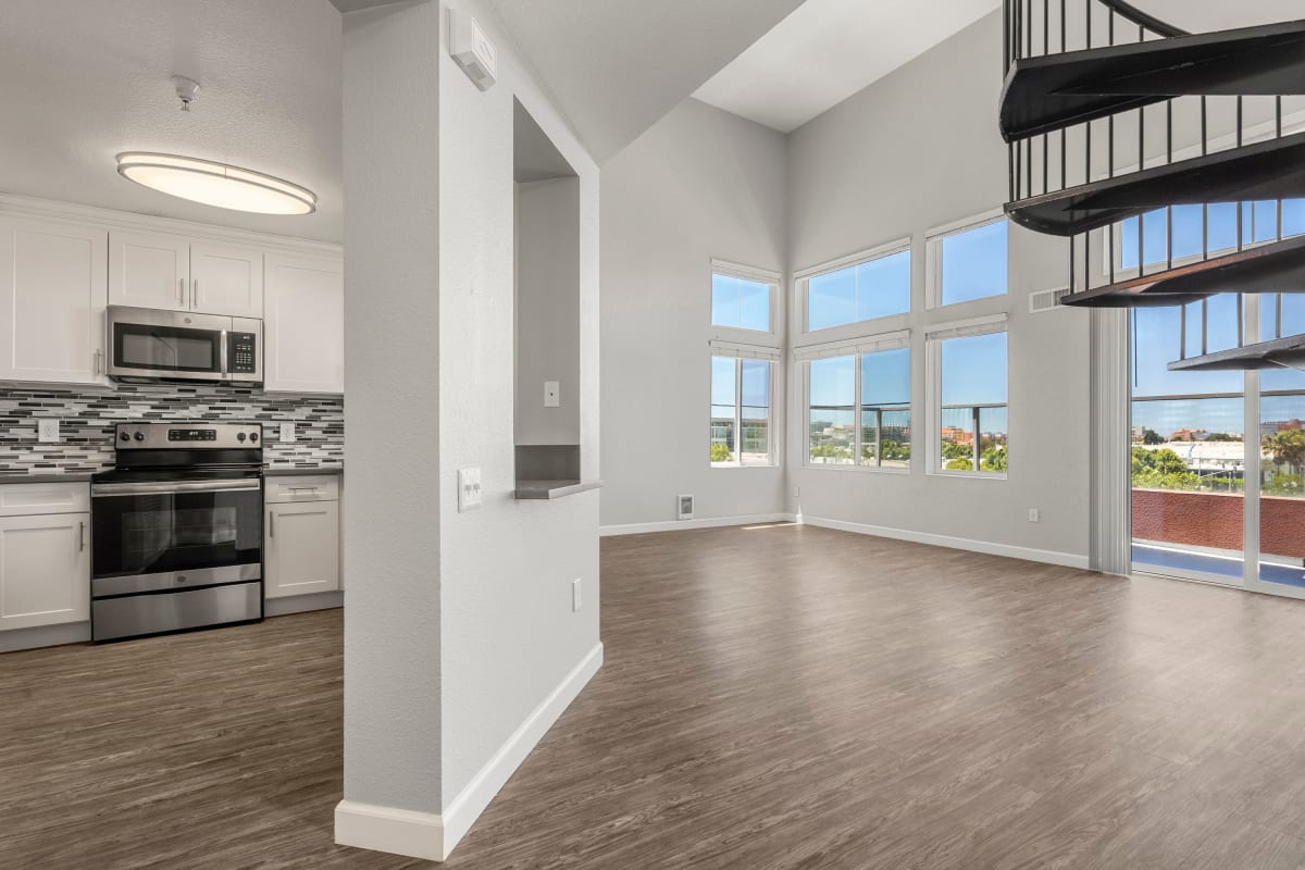 Model living space with stairs and modern kitchen at The Bridge at Emeryville in Emeryville, California