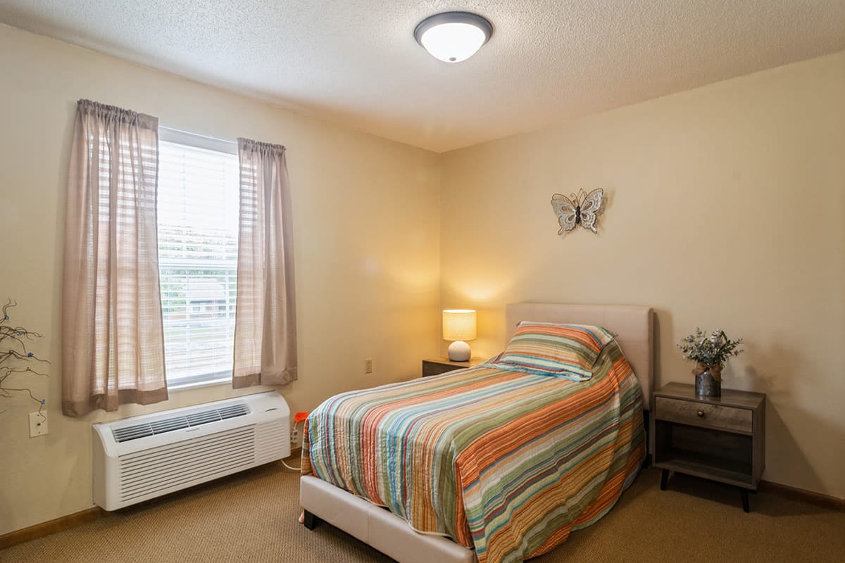 Furnished resident bedroom with matching end tables at Trustwell Living at Mansfield Place in Mansfield, Ohio