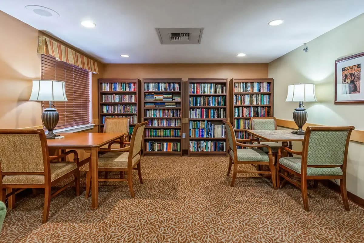 Resident library with multiple shelves and seating at Trustwell Living at Rock Run Place in Joliet, Illinois