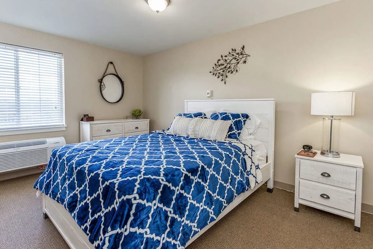 Resident bedroom with full size bed at Trustwell Living at Rock Run Place in Joliet, Illinois