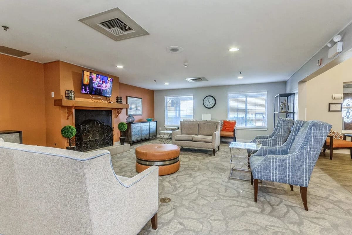Resident lounge area with multiple armchairs and sofa at Trustwell Living at Rock Run Place in Joliet, Illinois