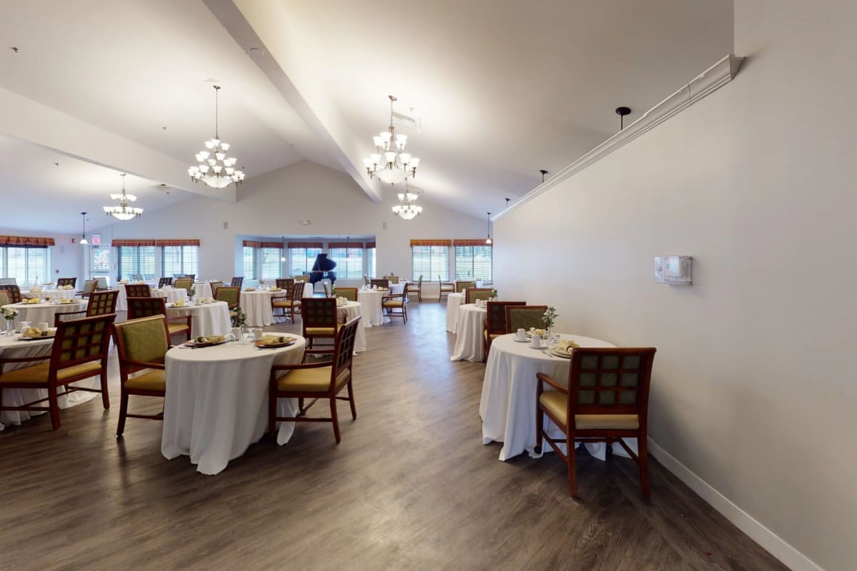Resident dining hall with chandeliers at Trustwell Living at Rock Run Place in Joliet, Illinois