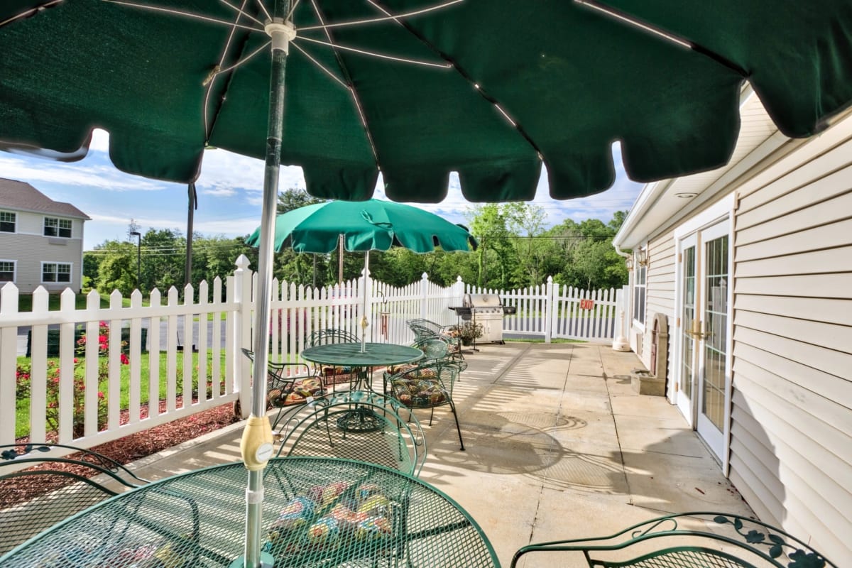 Outdoor seating with umbrellas at Trustwell Living at Westwood Place in Woodsfield, Ohio
