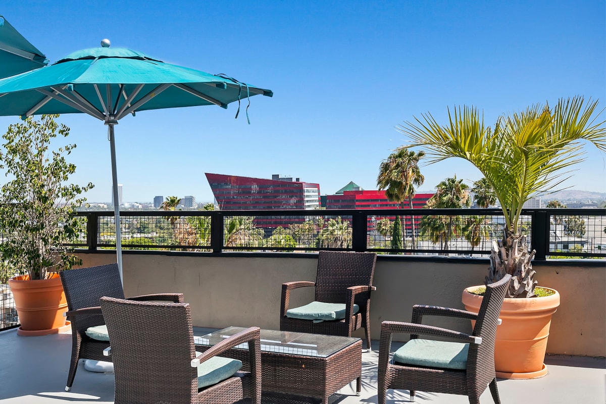Rooftop view patio with lounge chairs and umbrellas at Ascent, West Hollywood, California