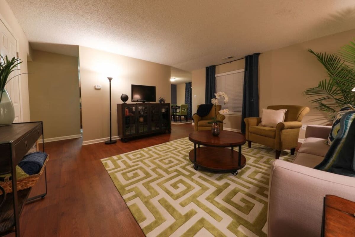 Model living space with large green patterned carpet at Farmington Gates in Germantown, Tennessee