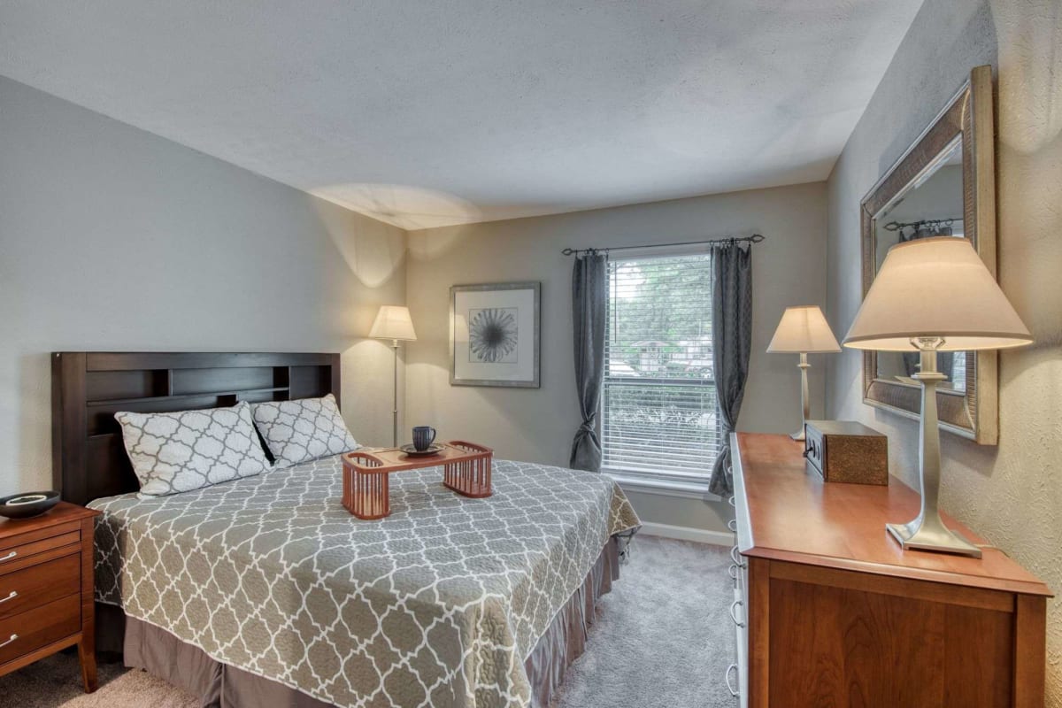 Resident bedroom with plush carpeting at Lakes at Lincoln in Greensboro, North Carolina