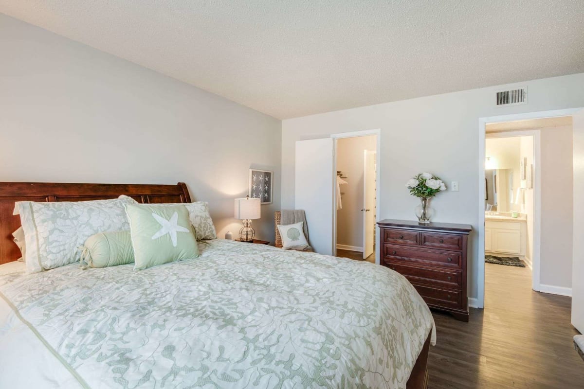 Resident bedroom with wood-style flooring at Oakleigh Apartments in Baton Rouge, Louisiana