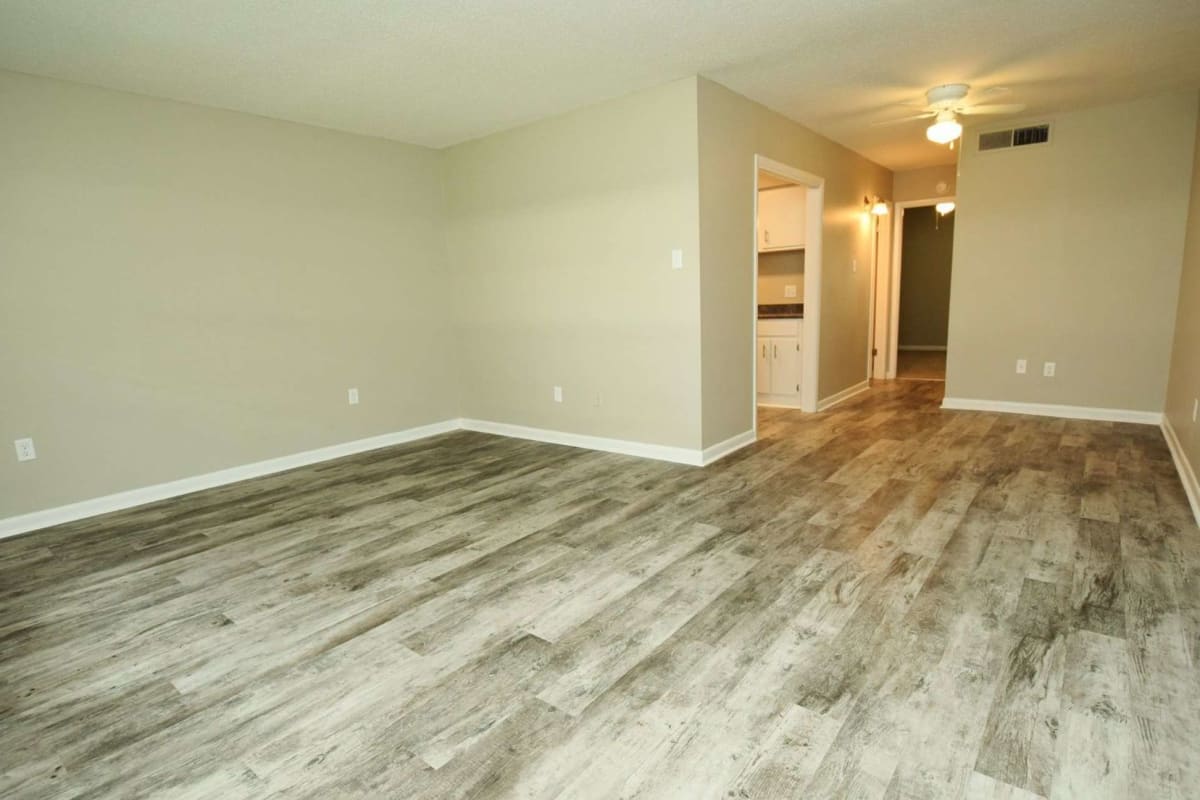 Open living space with wood-style flooring at Tiger Pointe in Baton Rouge, Louisiana