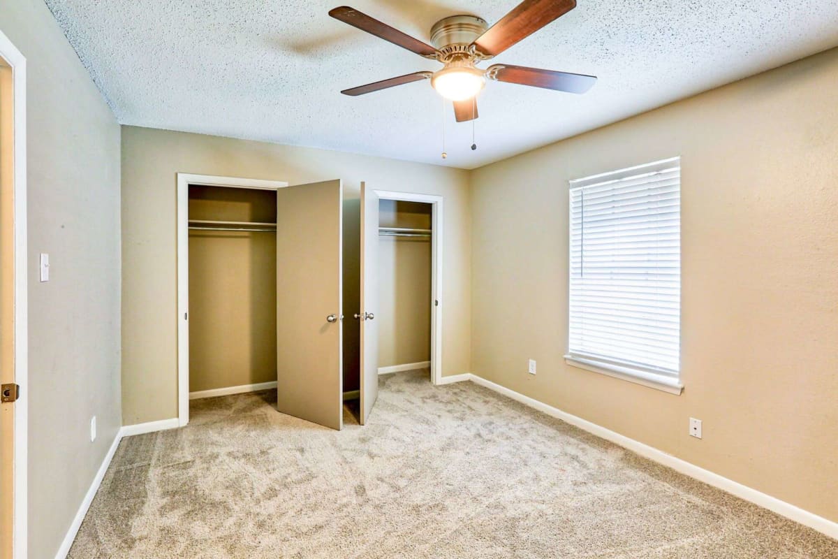 Bedroom with ceiling fan and plush carpeting at Tiger Pointe in Baton Rouge, Louisiana