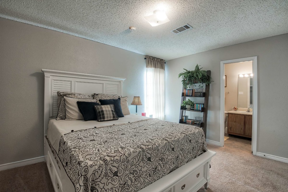 Resident master bedroom with plush carpeting at St. Germaine in Harvey, Louisiana
