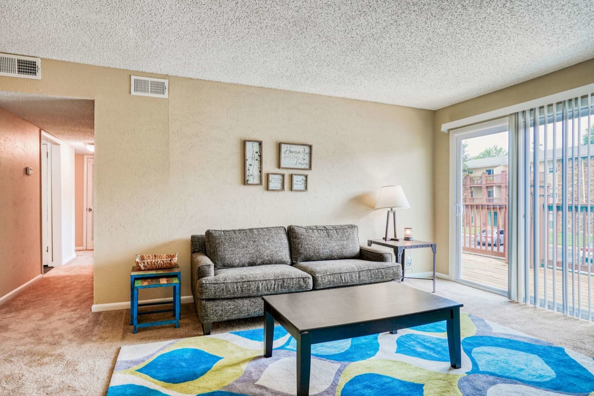 Resident living room with access to the balcony at Ashford Place in Clarksville, Tennessee