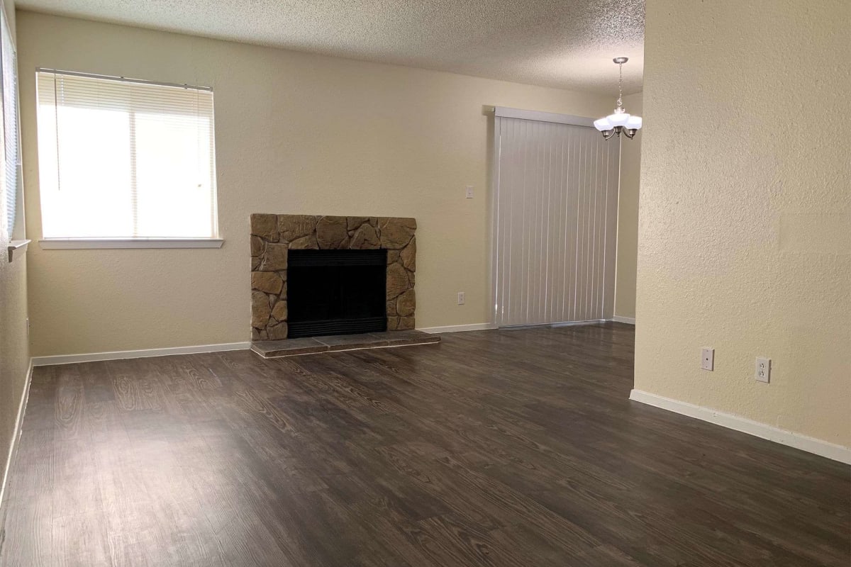 Living space with wood-style flooring and a fireplace at Stonehill in Killeen, Texas