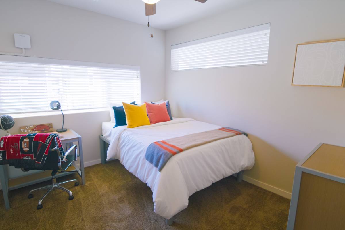 Bedroom with accent pillows at College Town Fayetteville in Fayetteville, Arkansas