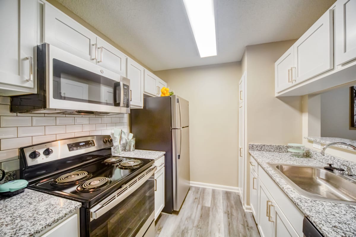 Resident kitchen with wood-style flooring at Buena Vista in Seminole, Florida