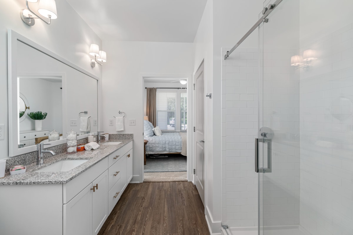 A bathroom with double sinks and a walk-in shower at The Griffon Vero Beach | Apartments in Vero Beach, Florida
