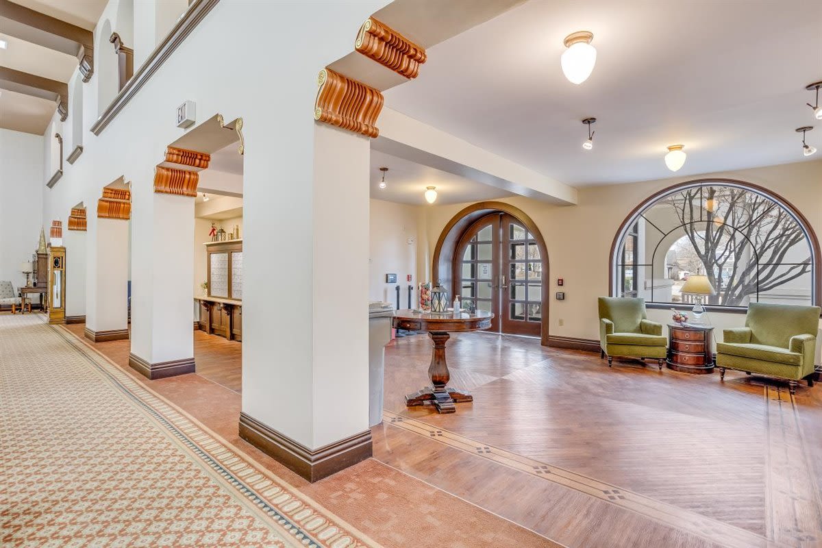 Resident lounge area with armchairs and hardwood flooring at Oxford Vista Wichita in Wichita, Kansas