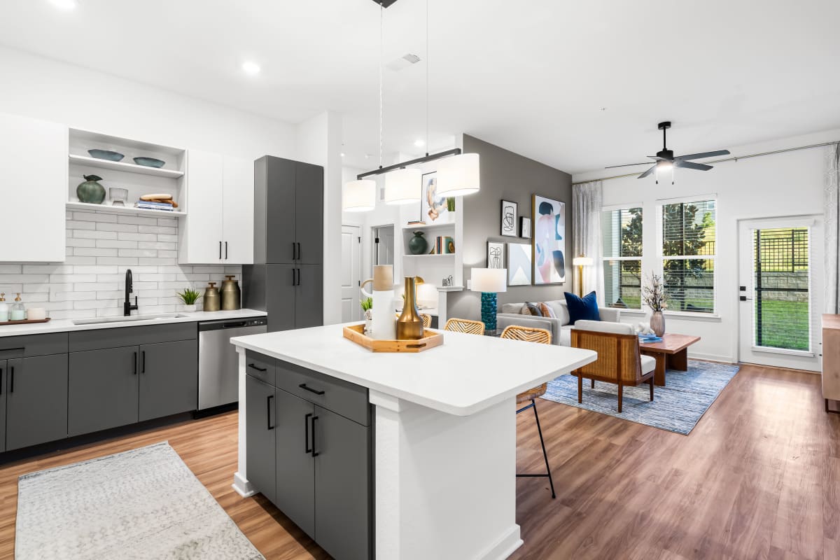 Wood flooring in a furnished living room and open kitchen at Integra Heights in Clermont, Florida