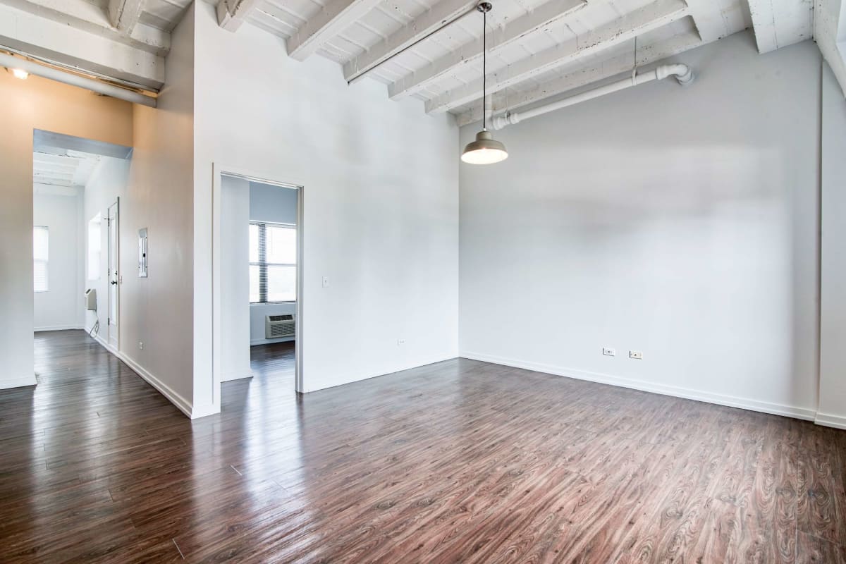 Large open living space with wood-style flooring at The Maynard at 5718 N Winthrop in Chicago, Illinois