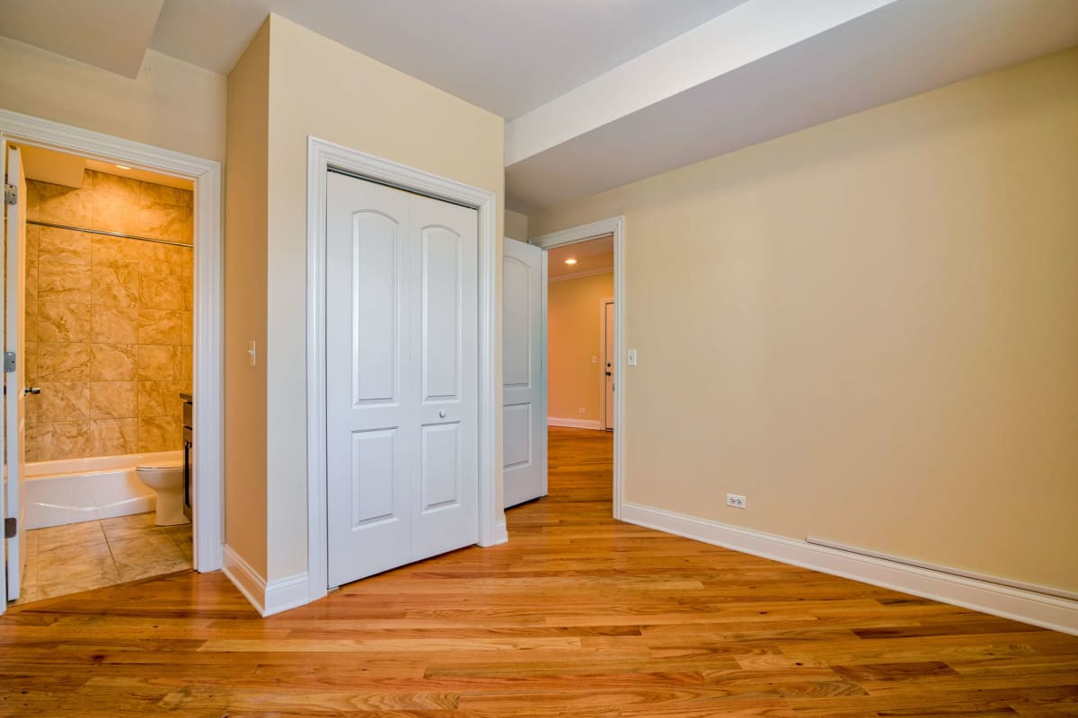 Resident master bedroom with wood-style flooring at The Maynard at 4014 N Central Park in Chicago, Illinois